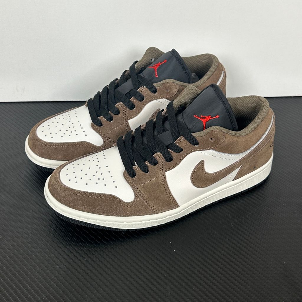 Side profile of the Air Jordan 1 Low sneaker featuring a crisp white leather base, rich earthy brown Palomino overlays, a striking Wild Berry purple Swoosh, and a classic white midsole.