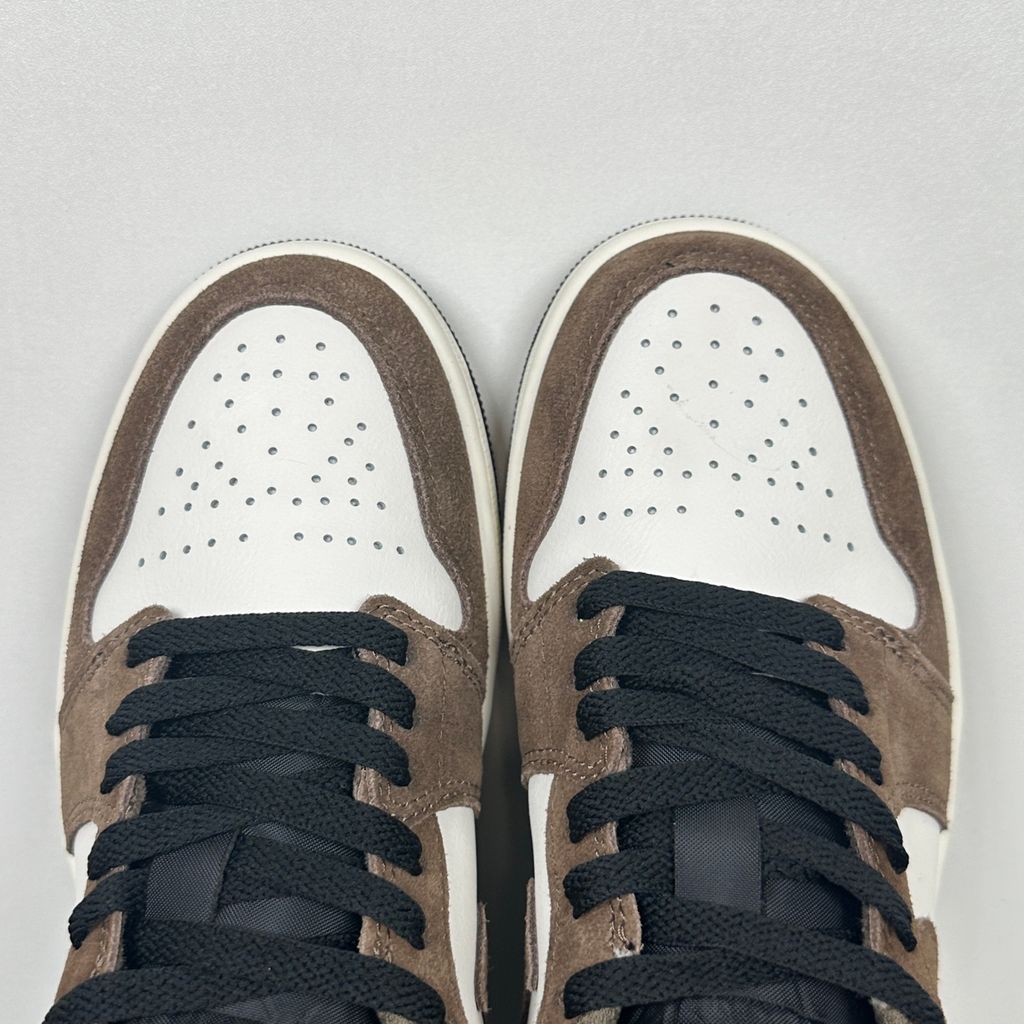 Side profile of the Air Jordan 1 Low sneaker featuring a crisp white leather base, rich earthy brown Palomino overlays, a striking Wild Berry purple Swoosh, and a classic white midsole.