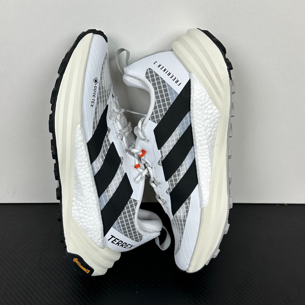 Side profile of the adidas Terrex Freehiker 3 Low GORE-TEX sneaker featuring a breathable white mesh upper equipped with a waterproof membrane, durable black synthetic overlays, and a rugged Continental Rubber outsole with aggressive traction lugs.