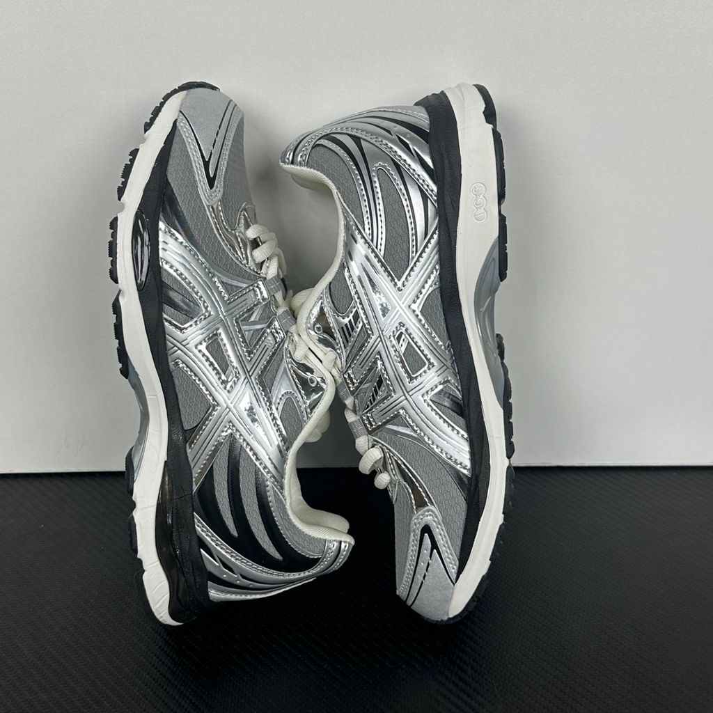 Side profile of the ASICS Gel-Sekiran sneaker featuring a breathable gravel grey mesh upper, dynamic metallic pure silver synthetic overlays, and a sculpted midsole equipped with visible GEL technology cushioning.