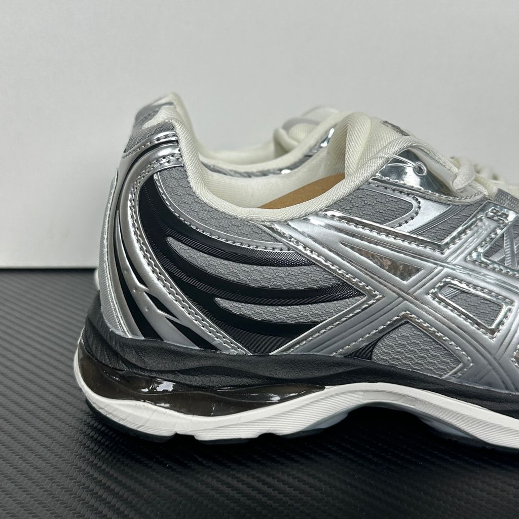 Side profile of the ASICS Gel-Sekiran sneaker featuring a breathable gravel grey mesh upper, dynamic metallic pure silver synthetic overlays, and a sculpted midsole equipped with visible GEL technology cushioning.