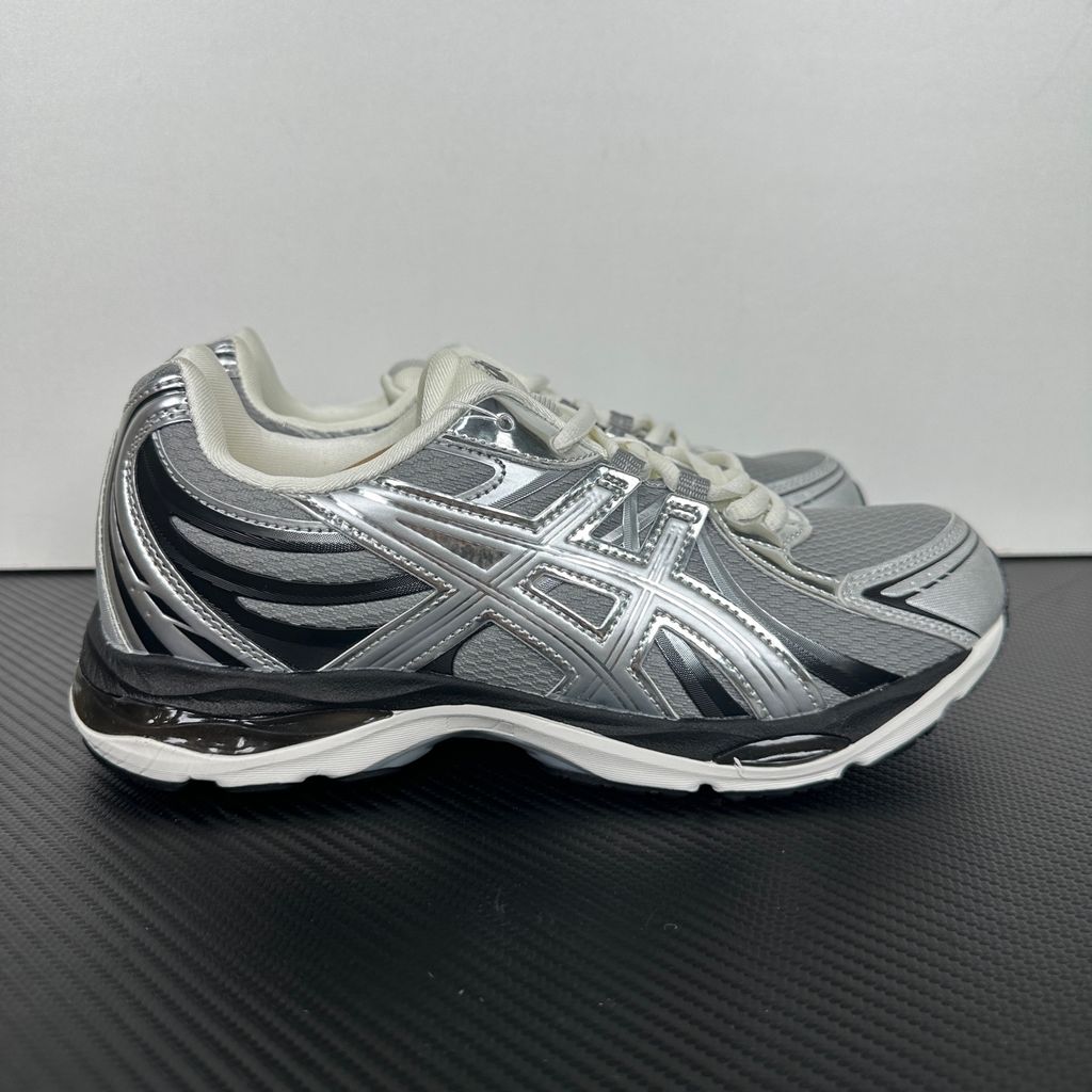 Side profile of the ASICS Gel-Sekiran sneaker featuring a breathable gravel grey mesh upper, dynamic metallic pure silver synthetic overlays, and a sculpted midsole equipped with visible GEL technology cushioning.