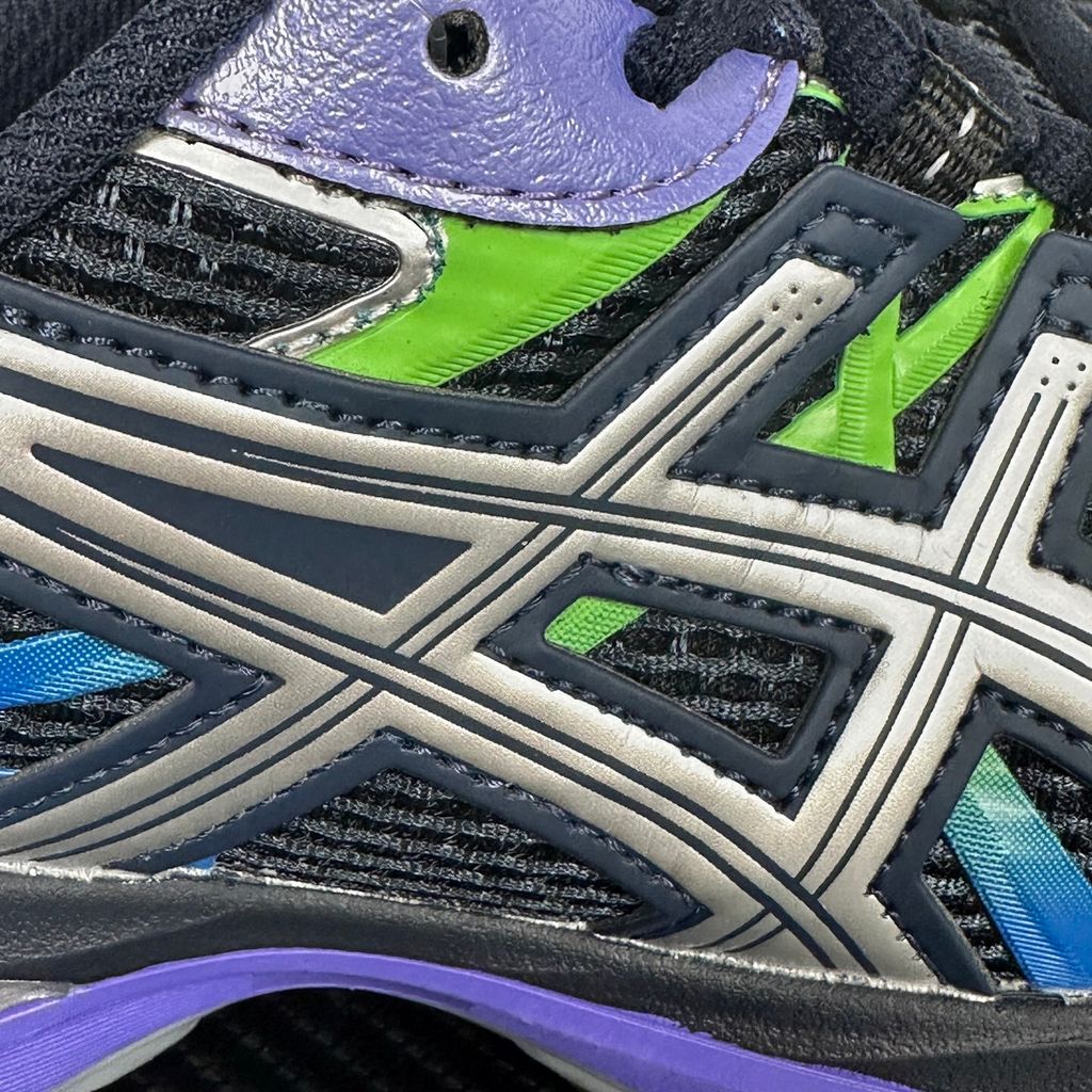 Side profile of the ASICS Gel-Sekiran sneaker featuring a breathable midnight navy mesh upper, dynamic metallic pure silver synthetic overlays, and a sculpted midsole equipped with visible GEL technology cushioning.