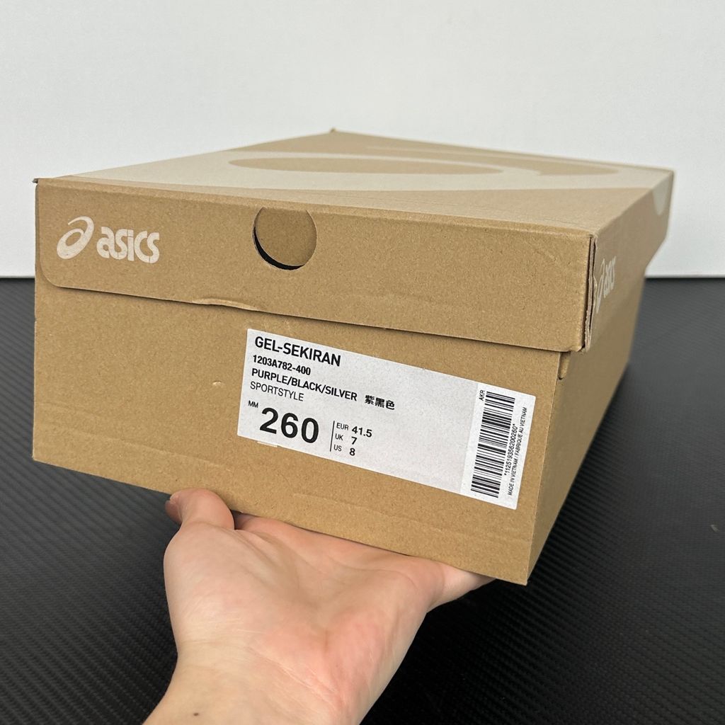 Side profile of the ASICS Gel-Sekiran sneaker featuring a breathable midnight navy mesh upper, dynamic metallic pure silver synthetic overlays, and a sculpted midsole equipped with visible GEL technology cushioning.