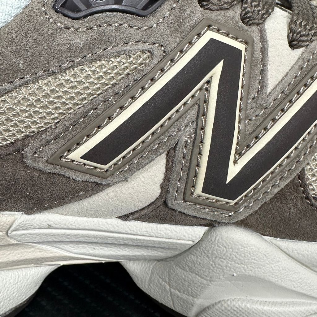 Side profile of the New Balance 9060 sneaker featuring a breathable thunder grey mesh base, rich brown premium suede and nubuck overlays, stonewear accents, the classic 'N' logo, and an exaggerated, sculpted chunky midsole.