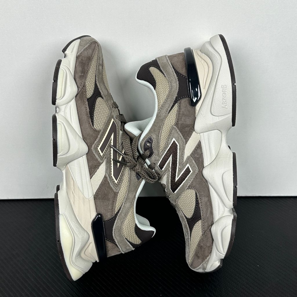 Side profile of the New Balance 9060 sneaker featuring a breathable thunder grey mesh base, rich brown premium suede and nubuck overlays, stonewear accents, the classic 'N' logo, and an exaggerated, sculpted chunky midsole.