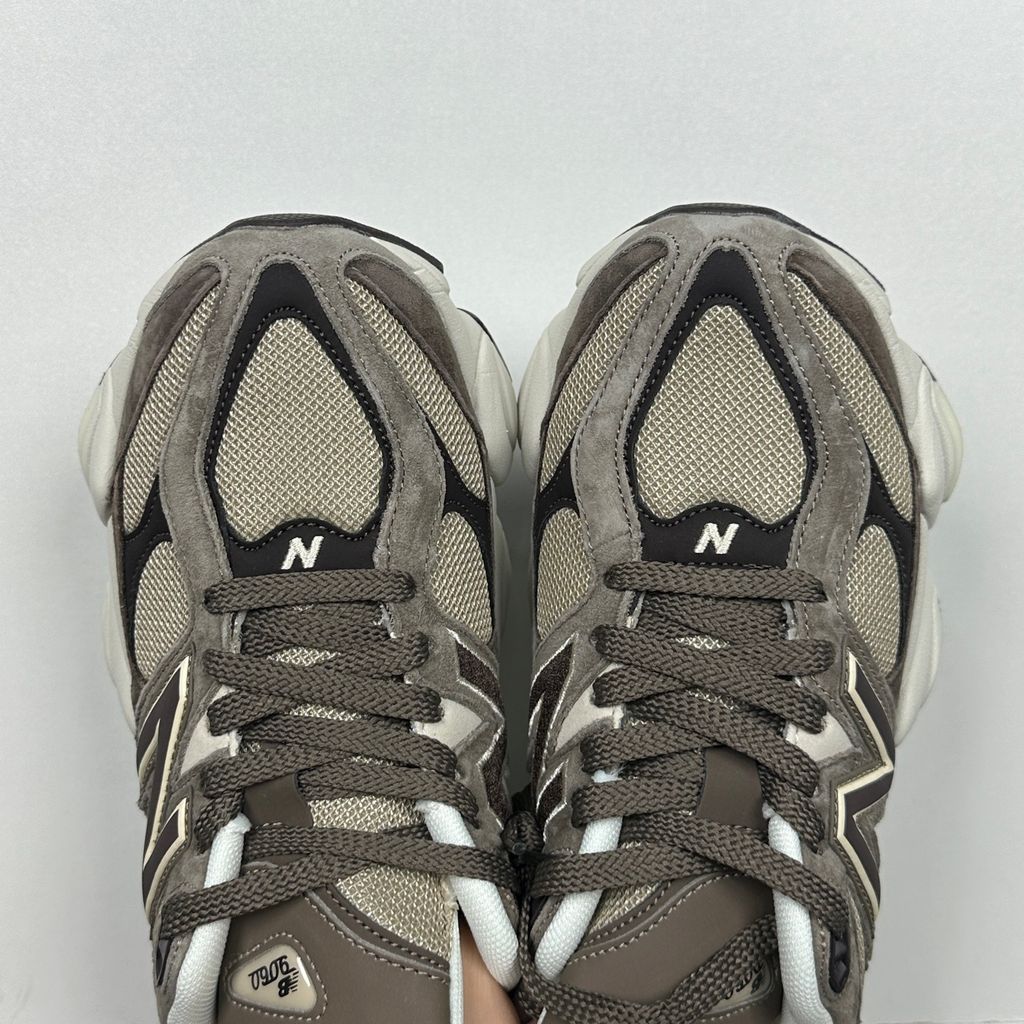 Side profile of the New Balance 9060 sneaker featuring a breathable thunder grey mesh base, rich brown premium suede and nubuck overlays, stonewear accents, the classic 'N' logo, and an exaggerated, sculpted chunky midsole.