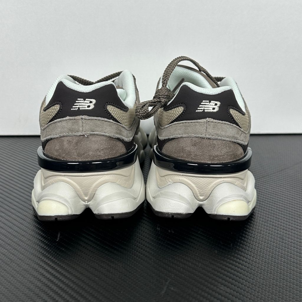 Side profile of the New Balance 9060 sneaker featuring a breathable thunder grey mesh base, rich brown premium suede and nubuck overlays, stonewear accents, the classic 'N' logo, and an exaggerated, sculpted chunky midsole.
