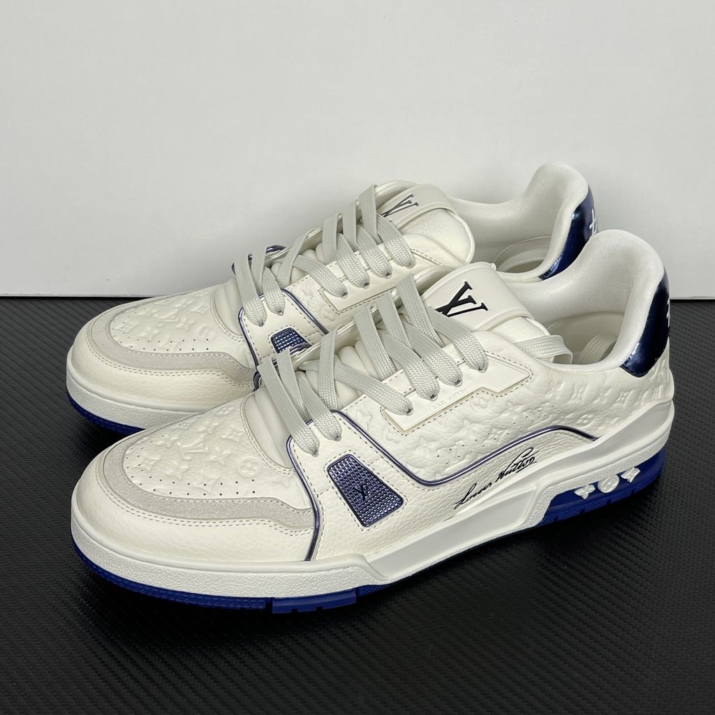 Side profile of Louis Vuitton LV Trainer Sneaker in Marine navy 1AKCPO with Monogram-debossed calf leather and contrasting trim.