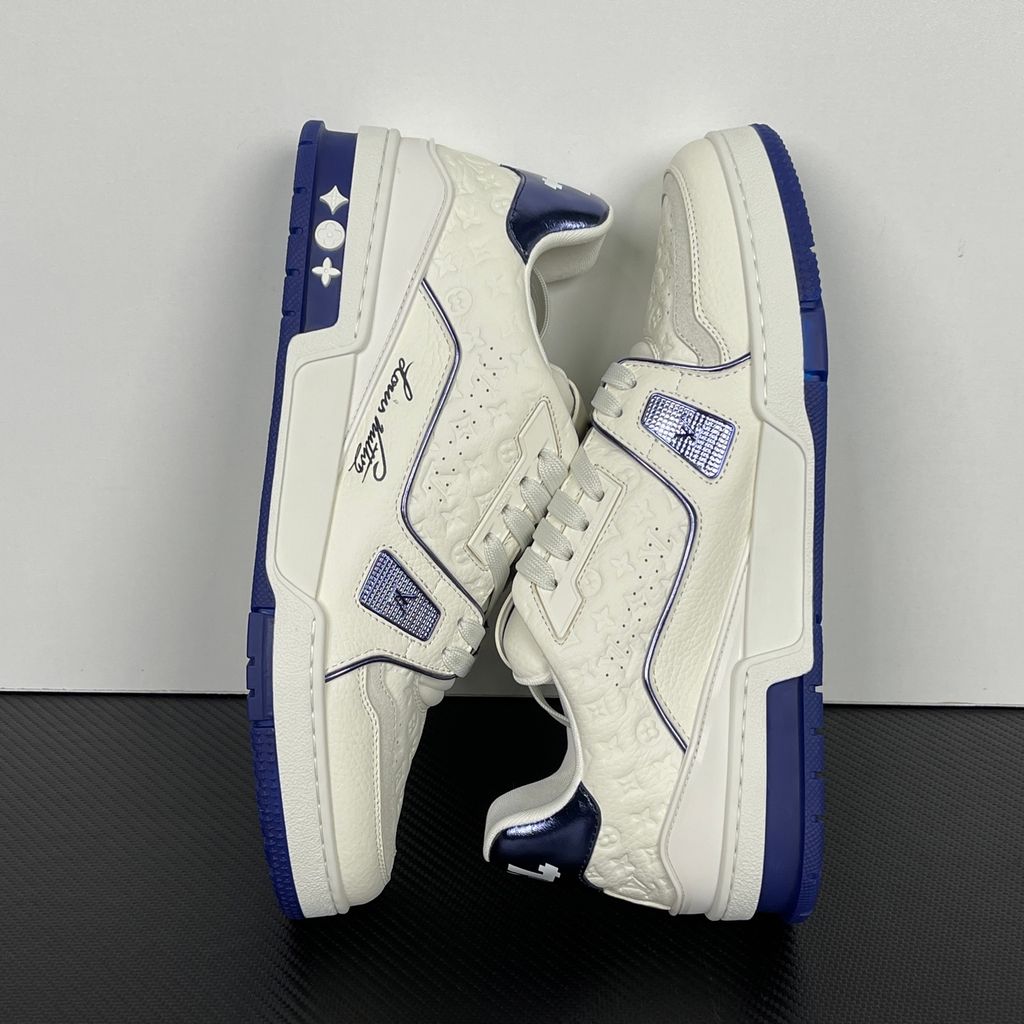 Side profile of Louis Vuitton LV Trainer Sneaker in Marine navy 1AKCPO with Monogram-debossed calf leather and contrasting trim.
