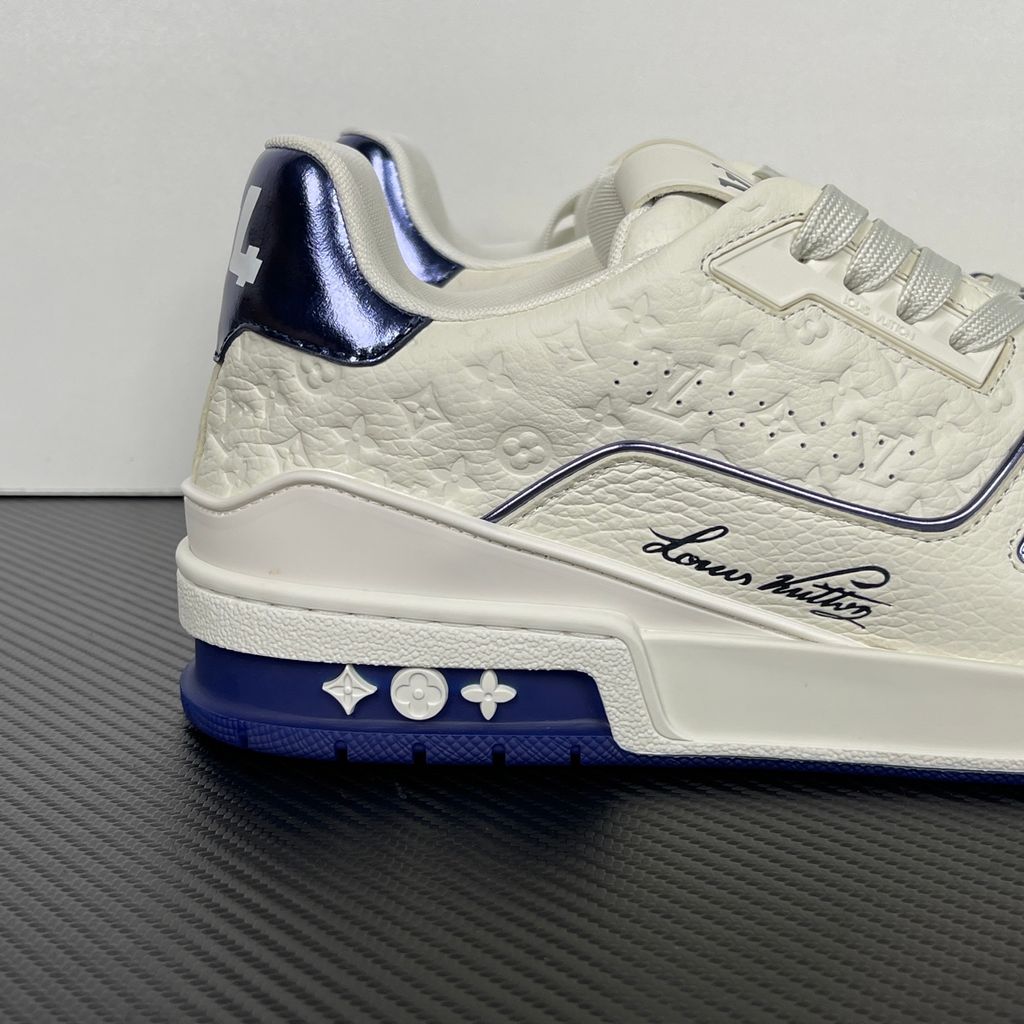 Side profile of Louis Vuitton LV Trainer Sneaker in Marine navy 1AKCPO with Monogram-debossed calf leather and contrasting trim.