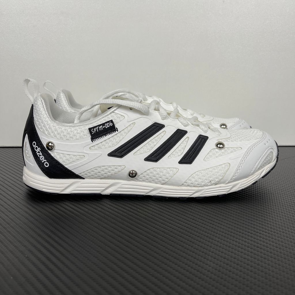 Alt text: Side profile of adidas Adizero PR x Song for the Mute HP3524 in white and black with mesh panels, Three Stripes and silver-tone studs.