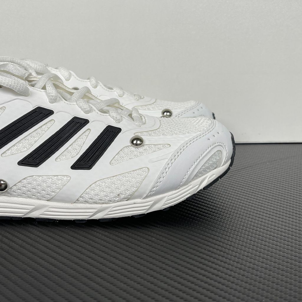 Alt text: Side profile of adidas Adizero PR x Song for the Mute HP3524 in white and black with mesh panels, Three Stripes and silver-tone studs.