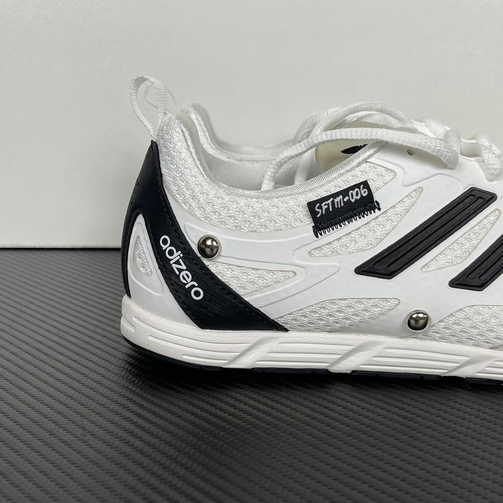 Alt text: Side profile of adidas Adizero PR x Song for the Mute HP3524 in white and black with mesh panels, Three Stripes and silver-tone studs.