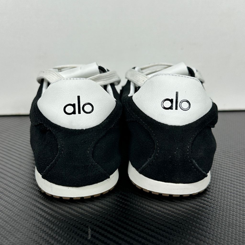 The ALO Sunset Sneaker Black/Ivory (A0891U) is a low-profile lifestyle sneaker inspired by the polished street style of Sunset Boulevard. It combines a black suede upper, contrasting Ivory details, recovery-foam cushioning and a flat gum-rubber outsole.