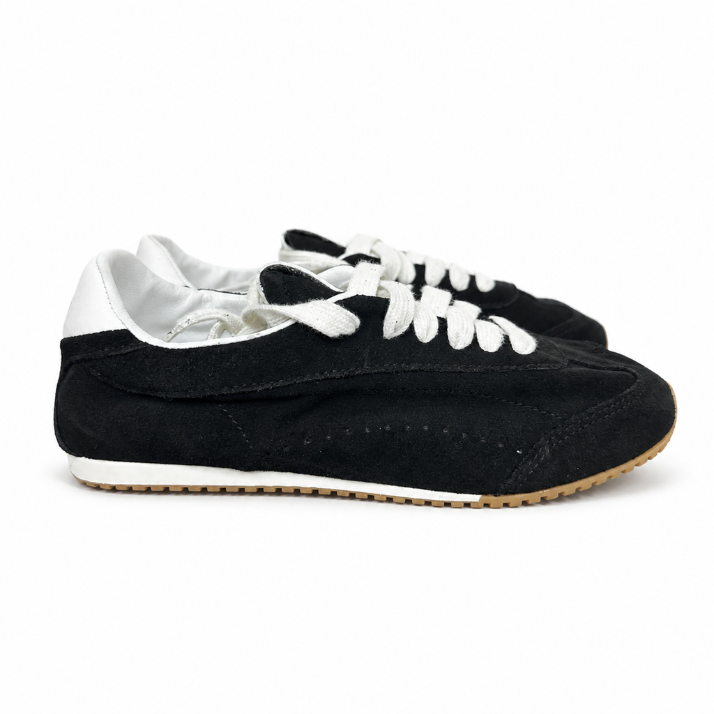 The ALO Sunset Sneaker Black/Ivory (A0891U) is a low-profile lifestyle sneaker inspired by the polished street style of Sunset Boulevard. It combines a black suede upper, contrasting Ivory details, recovery-foam cushioning and a flat gum-rubber outsole.