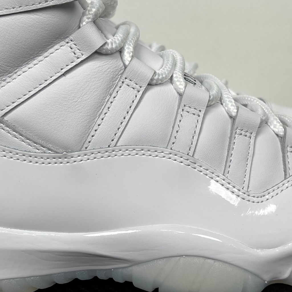 Jordan 11 Retro Comme des Garçons Homme Plus White IV7639-100 sneaker with a premium leather upper, tonal patent mudguard and CDG branding, side view.