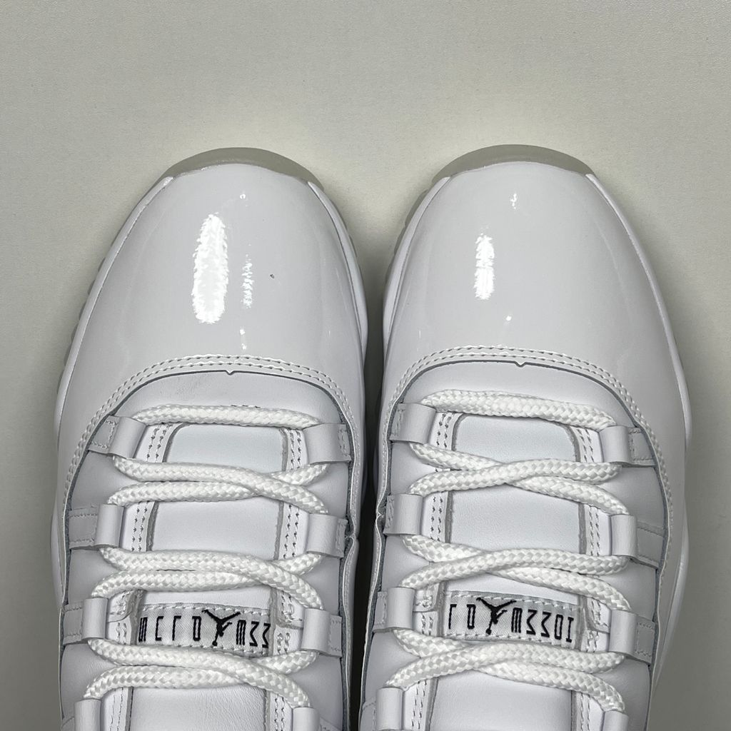 Jordan 11 Retro Comme des Garçons Homme Plus White IV7639-100 sneaker with a premium leather upper, tonal patent mudguard and CDG branding, side view.