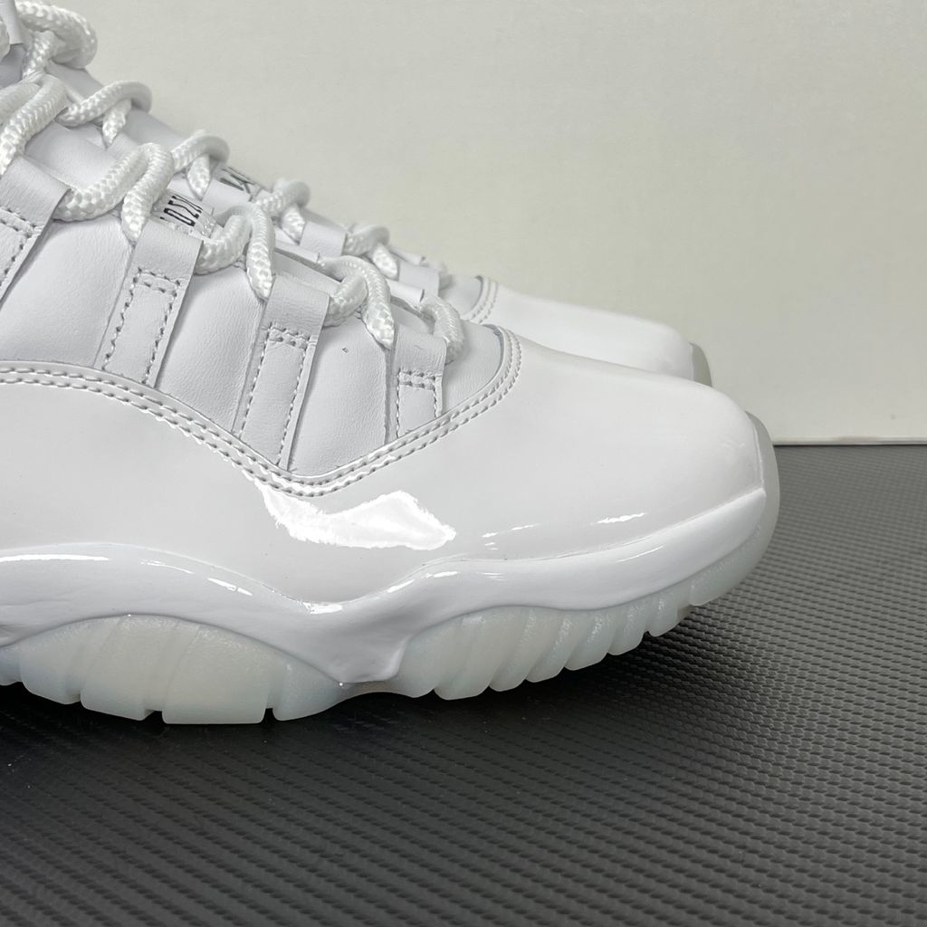 Jordan 11 Retro Comme des Garçons Homme Plus White IV7639-100 sneaker with a premium leather upper, tonal patent mudguard and CDG branding, side view.