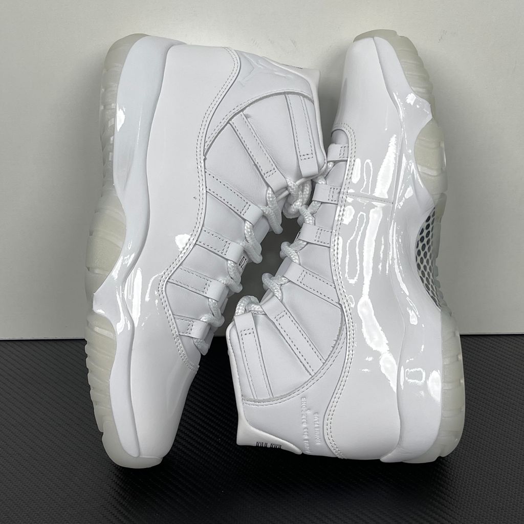 Jordan 11 Retro Comme des Garçons Homme Plus White IV7639-100 sneaker with a premium leather upper, tonal patent mudguard and CDG branding, side view.