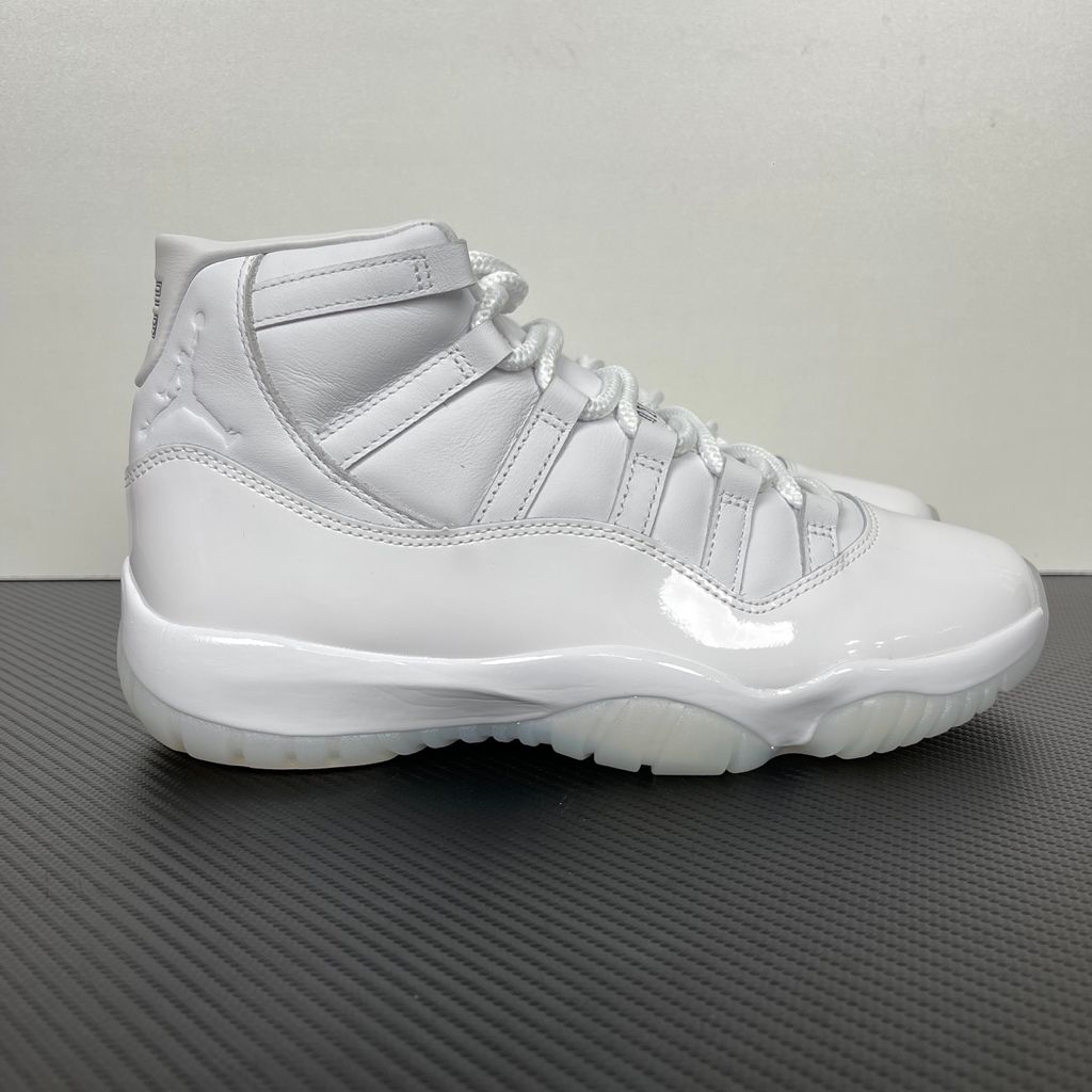 Jordan 11 Retro Comme des Garçons Homme Plus White IV7639-100 sneaker with a premium leather upper, tonal patent mudguard and CDG branding, side view.