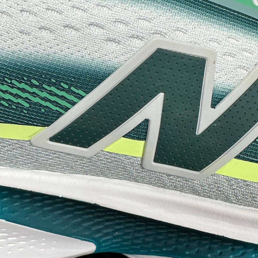 New Balance Ellipse v1 Deep End Glint Blue MELPS4B2 men’s running shoe with a breathable blue mesh upper, Fresh Foam X midsole and green accents, side view.