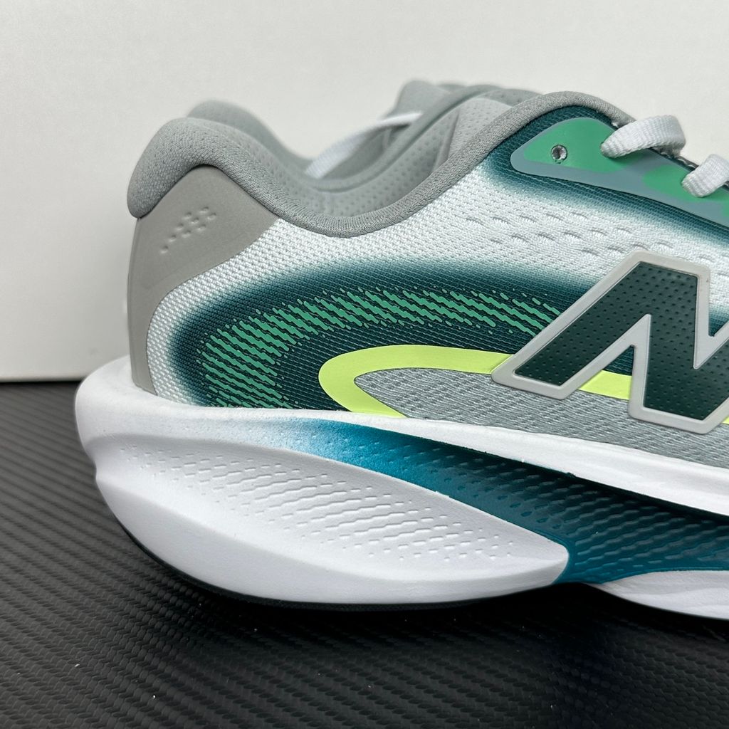 New Balance Ellipse v1 Deep End Glint Blue MELPS4B2 men’s running shoe with a breathable blue mesh upper, Fresh Foam X midsole and green accents, side view.