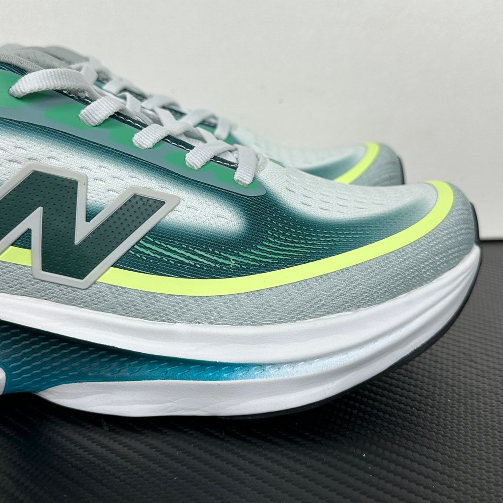 New Balance Ellipse v1 Deep End Glint Blue MELPS4B2 men’s running shoe with a breathable blue mesh upper, Fresh Foam X midsole and green accents, side view.