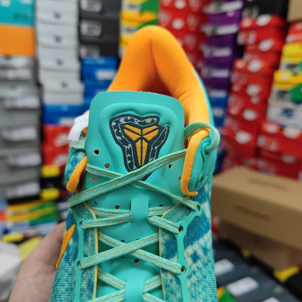 Side profile of the Nike Kobe 8 System 'Green Glow' basketball sneaker featuring a highly textured green reptile-scaled Engineered Mesh upper, a striking Laser Orange Nike Swoosh, Mineral Teal accents, and a low-profile cushioned midsole.