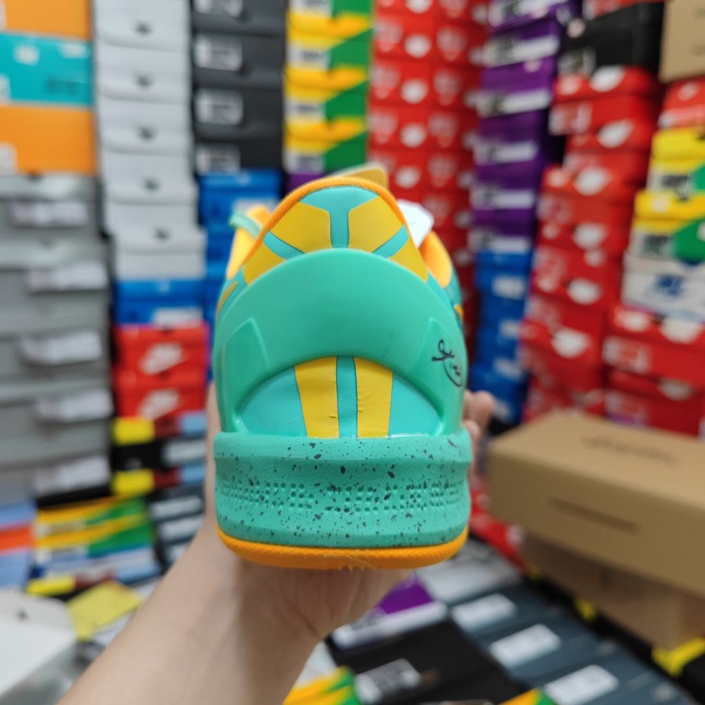 Side profile of the Nike Kobe 8 System 'Green Glow' basketball sneaker featuring a highly textured green reptile-scaled Engineered Mesh upper, a striking Laser Orange Nike Swoosh, Mineral Teal accents, and a low-profile cushioned midsole.