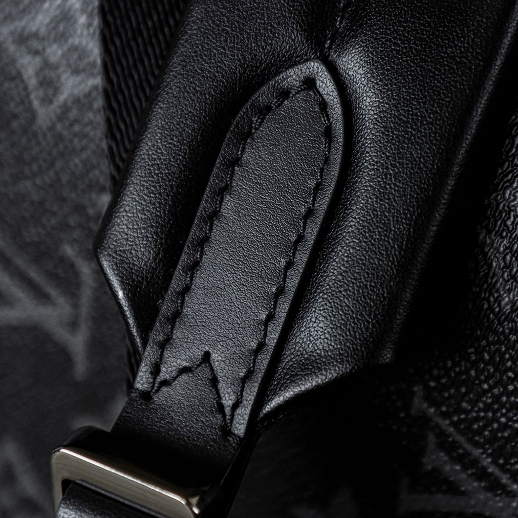 Front view of the authentic Louis Vuitton Discovery Backpack PM (image_b57668.jpg) featuring the iconic Monogram Eclipse grey and black coated canvas, a front zippered compartment, sleek black leather trim, and polished silver-tone hardware.