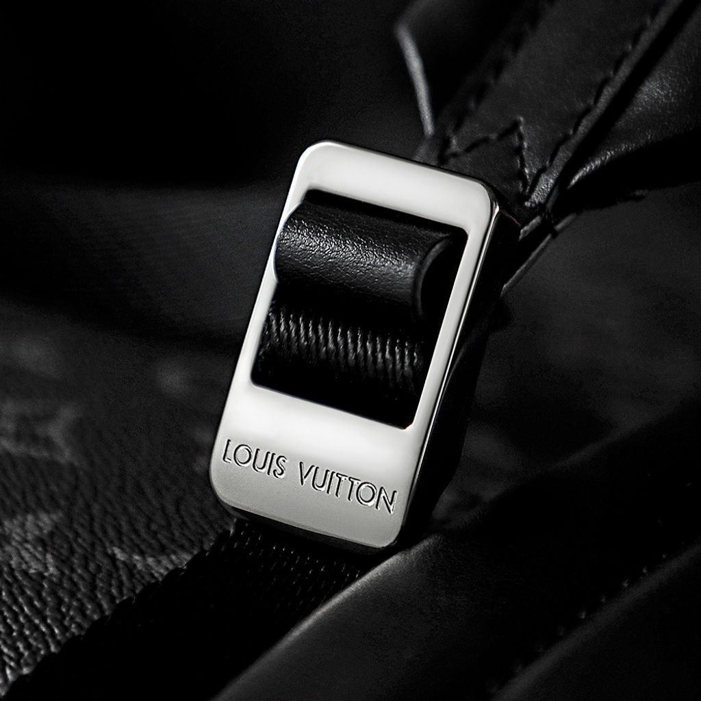 Front view of the authentic Louis Vuitton Discovery Backpack PM (image_b57668.jpg) featuring the iconic Monogram Eclipse grey and black coated canvas, a front zippered compartment, sleek black leather trim, and polished silver-tone hardware..jpg