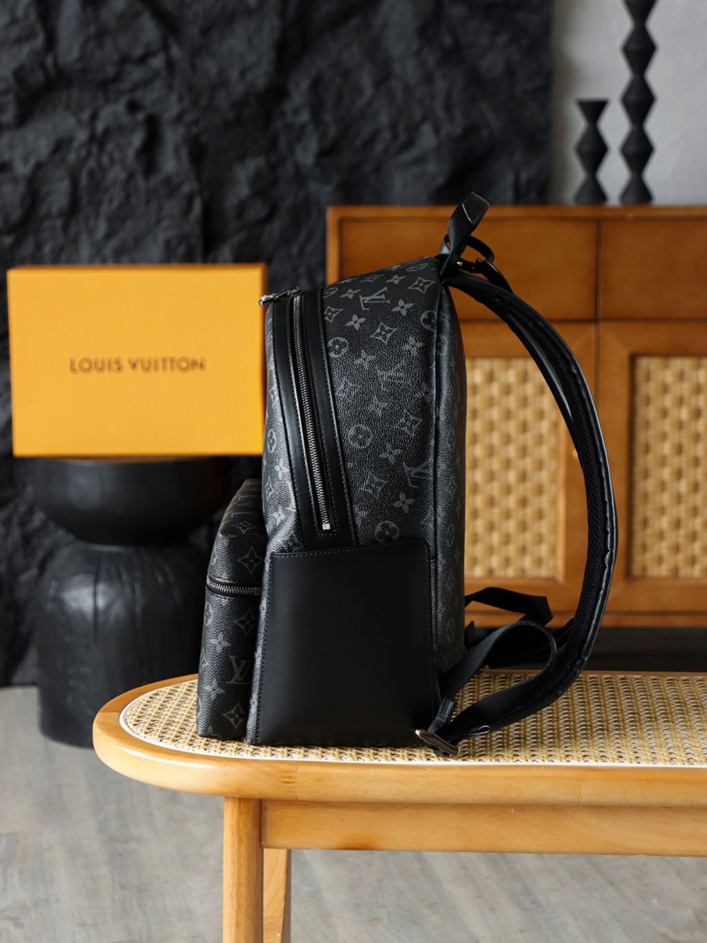 Front view of the authentic Louis Vuitton Discovery Backpack PM (image_b57668.jpg) featuring the iconic Monogram Eclipse grey and black coated canvas, a front zippered compartment, sleek black leather trim, and polished silver-tone hardware.