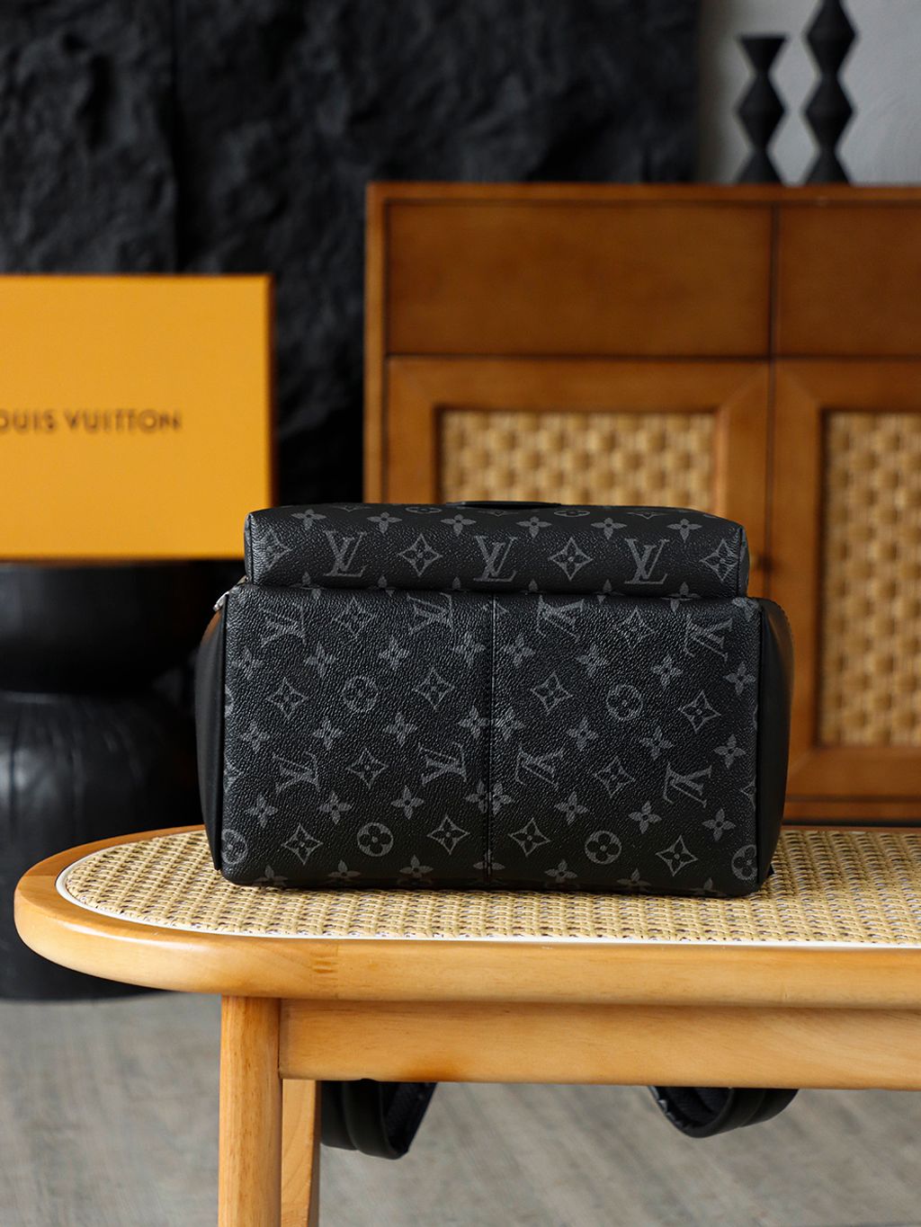 Front view of the authentic Louis Vuitton Discovery Backpack PM (image_b57668.jpg) featuring the iconic Monogram Eclipse grey and black coated canvas, a front zippered compartment, sleek black leather trim, and polished silver-tone hardware.