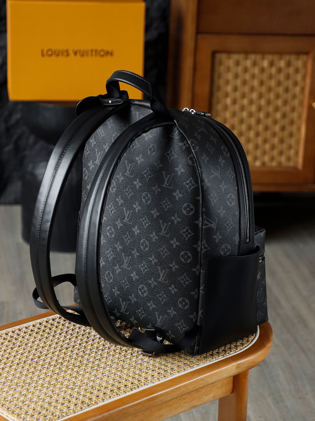 Front view of the authentic Louis Vuitton Discovery Backpack PM (image_b57668.jpg) featuring the iconic Monogram Eclipse grey and black coated canvas, a front zippered compartment, sleek black leather trim, and polished silver-tone hardware.