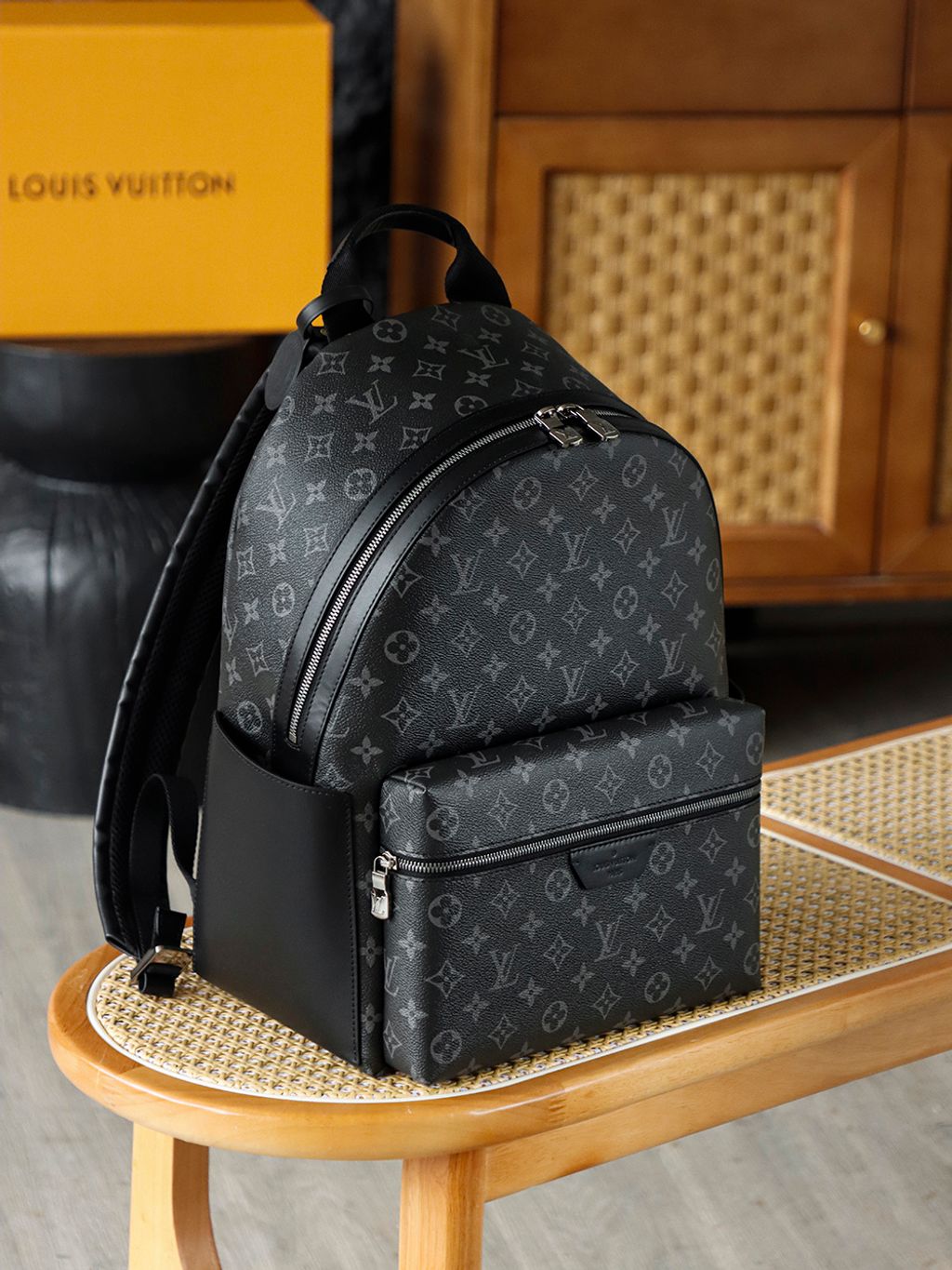 Front view of the authentic Louis Vuitton Discovery Backpack PM (image_b57668.jpg) featuring the iconic Monogram Eclipse grey and black coated canvas, a front zippered compartment, sleek black leather trim, and polished silver-tone hardware..jpg