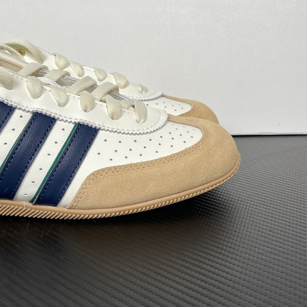 Shop adidas Chang Le LA1355 in Core White and Warm Sandstone with perforated tumbled leather, double-stitched T-toe detailing and a low-profile retro silhouette.