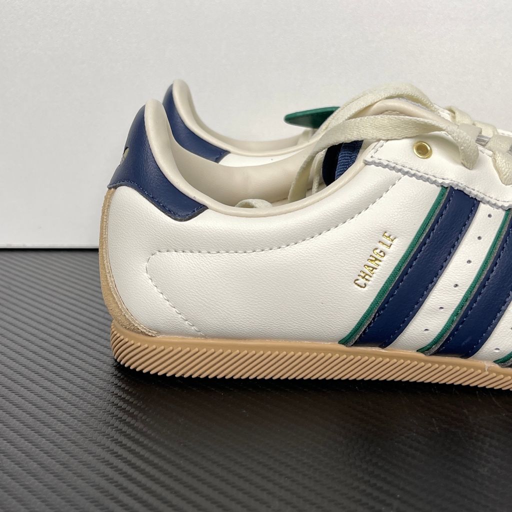 Shop adidas Chang Le LA1355 in Core White and Warm Sandstone with perforated tumbled leather, double-stitched T-toe detailing and a low-profile retro silhouette.
