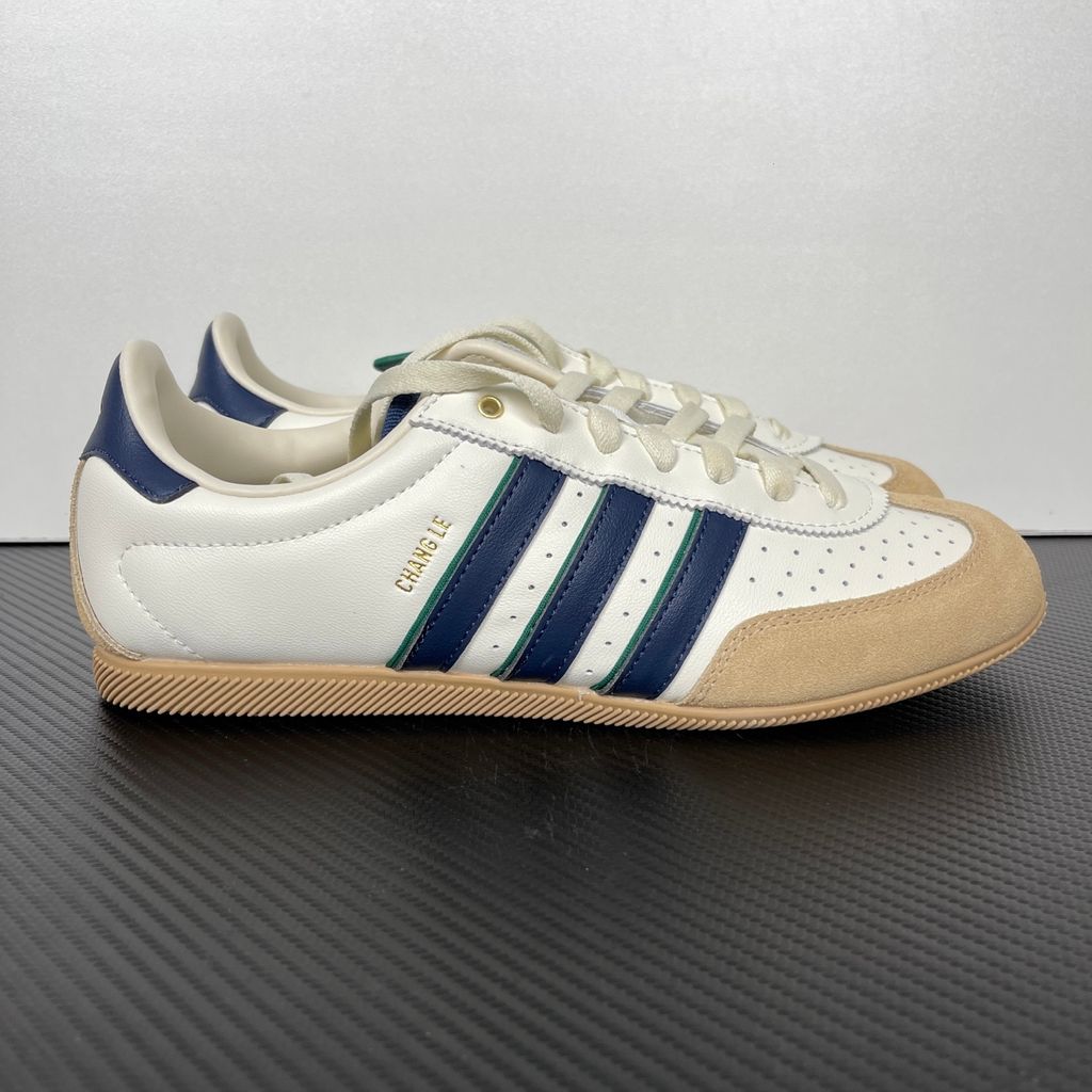 Shop adidas Chang Le LA1355 in Core White and Warm Sandstone with perforated tumbled leather, double-stitched T-toe detailing and a low-profile retro silhouette.