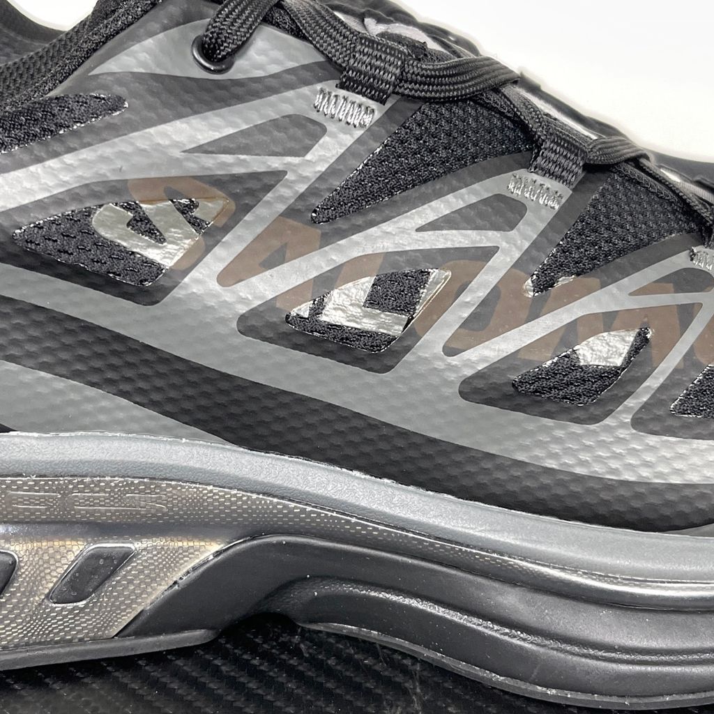 Shop MM6 Maison Margiela x Salomon XT-MM6 L49200300 in Black and Grey with technical mesh, layered synthetic overlays, MM6 graphics and a sculpted rubber sole.