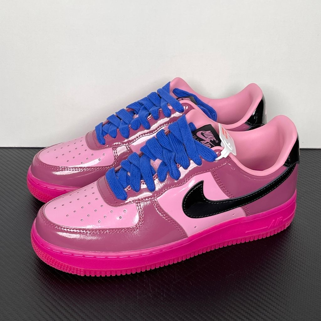 Shop Nike Air Force 1 Low IO4489-600 in Pink Cooler, Mulberry Rose, Hyper Blue and Black with glossy leather styling, Nike Air cushioning and rubber traction.