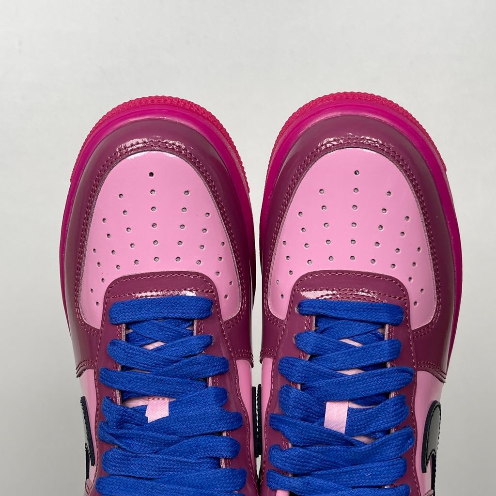 Shop Nike Air Force 1 Low IO4489-600 in Pink Cooler, Mulberry Rose, Hyper Blue and Black with glossy leather styling, Nike Air cushioning and rubber traction.
