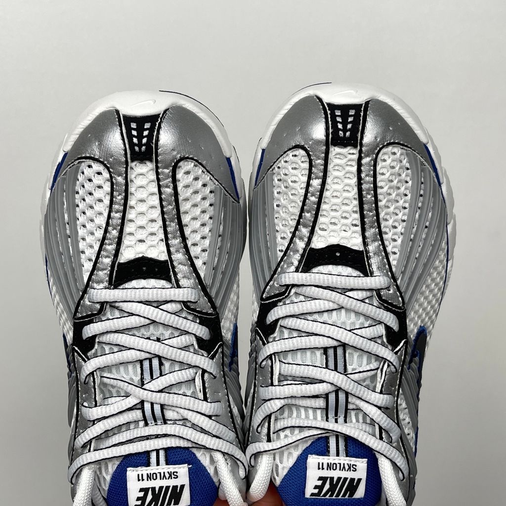 Shop Nike Zoom Skylon 11 IU1869-103 in White, Metallic Silver, Old Royal and Black with heel Air Zoom, Cushlon cushioning and flexible Y2K styling.
