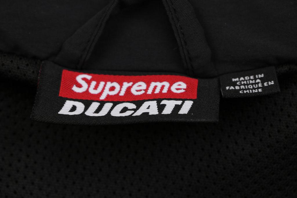 Supreme Ducati racing stand collar track jacket black matte technical fabric breathable mesh lining 3D silicone logo metal plaque YKK zipper unisex sizes S-XL