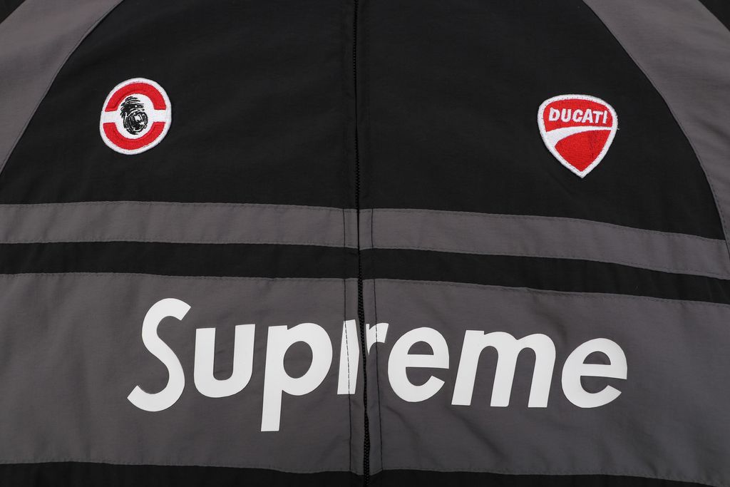 Supreme Ducati racing stand collar track jacket black matte technical fabric breathable mesh lining 3D silicone logo metal plaque YKK zipper unisex sizes S-XL