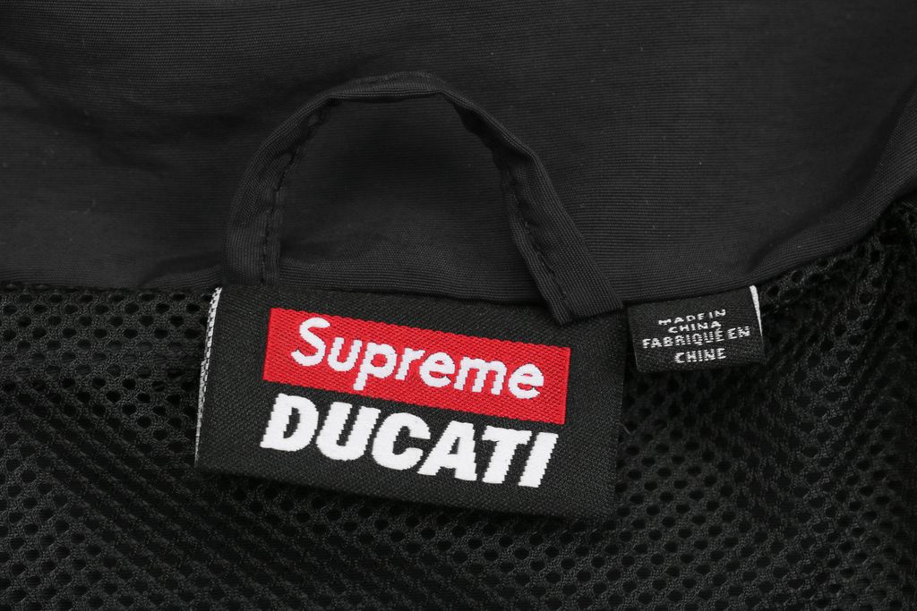 Supreme Ducati racing stand collar track jacket black matte technical fabric breathable mesh lining 3D silicone logo metal plaque YKK zipper unisex sizes S-XL