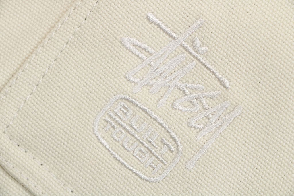 Stussy four pocket tonal jacquard embroidered work jacket beige structured fabric chest letter logo relaxed drop shoulder unisex utility outerwear sizes S-XL
