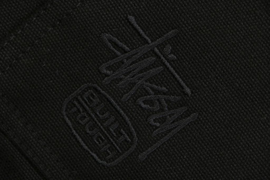 Stussy four pocket tonal jacquard embroidered work jacket black structured fabric chest letter logo relaxed drop shoulder unisex utility outerwear sizes S-XL