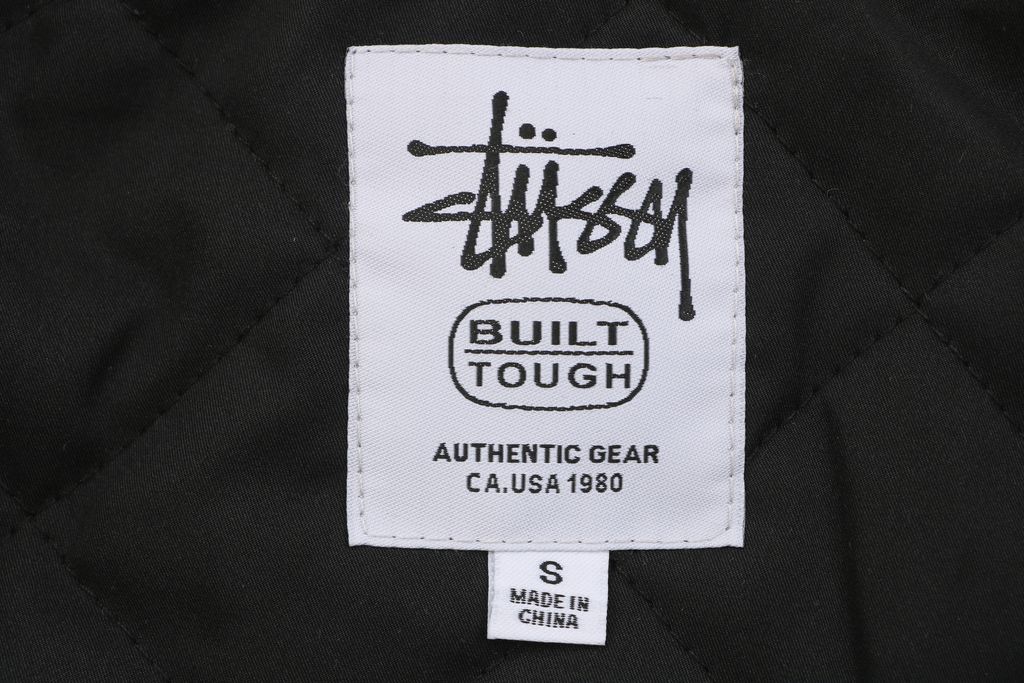 Stussy four pocket tonal jacquard embroidered work jacket black structured fabric chest letter logo relaxed drop shoulder unisex utility outerwear sizes S-XL