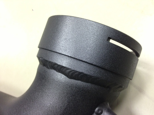 Close-up of CNC-machined throttle body flange on FTP intake pipe